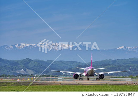 Sendai Airport on a sunny day: Zao mountain range and a plane taking off. Natori City, Miyagi Prefecture. Sendai Airport on a sunny day: Zao mountain range and a plane taking off. Natori City, Miyagi Prefecture. 139755947
