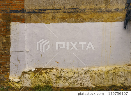Plain wall panel. Simple white rectangle painted over weathered brick and plaster with moss at bottom Plain wall panel. Simple white rectangle painted over weathered brick and plaster with moss at bottom 139756107