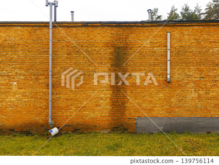 Weathered wall with moss and fixtures. Functional scene of mossy stained wall with pipes and bricks Weathered wall with moss and fixtures. Functional scene of mossy stained wall with pipes and bricks 139756114