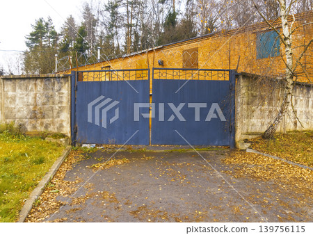 Hidden entrance with vivid contrast. Concealed compound entry with textured surfaces and autumn decor Hidden entrance with vivid contrast. Concealed compound entry with textured surfaces and autumn decor 139756115