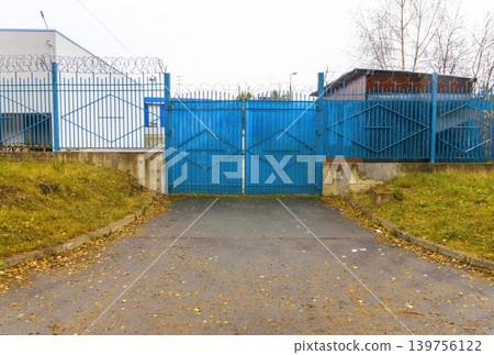 Decorative steel gate with lock. Enclosed driveway with decorative diamond pattern and locked gate Decorative steel gate with lock. Enclosed driveway with decorative diamond pattern and locked gate 139756122