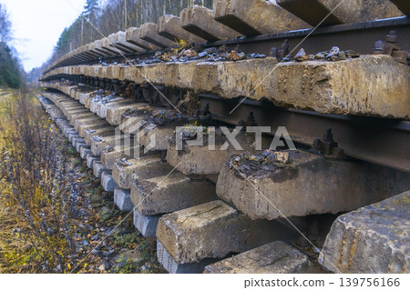 Stacked weathered concrete sleepers in industrial yard prepared for track replacement tasks 139756166