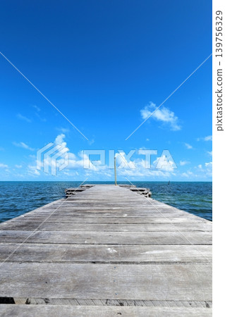 Caye Caulker, a Caribbean paradise: an old wooden pier and a panoramic view of the blue sky. Caye Caulker, a Caribbean paradise: an old wooden pier and a panoramic view of the blue sky. 139756329