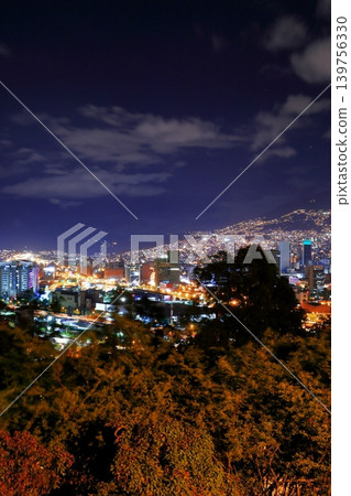 Panoramic night view of Medellín, Colombia, South America, with city lights shining against the Andes Mountains. Panoramic night view of Medellín, Colombia, South America, with city lights shining against the Andes Mountains. 139756330