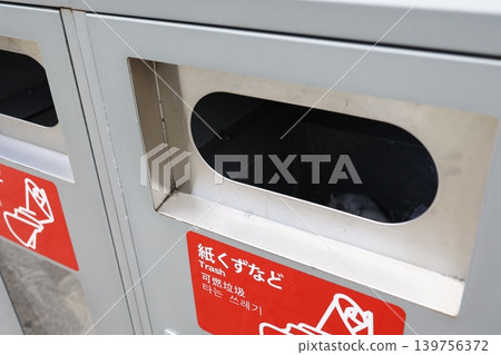 A trash can for burnable waste such as paper scraps. It has a red label. It's a metal container. Separate collection is required. A trash can for burnable waste such as paper scraps. It has a red label. It's a metal container. Separate collection is required. 139756372