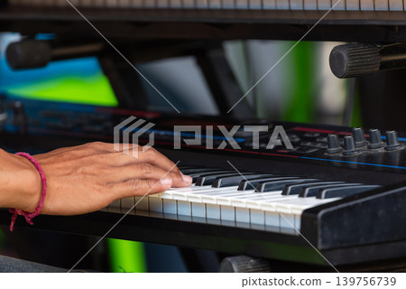 Hands playing electronic keyboard highlighting music performance creativity practice instrumental skill in closeup view Hands playing electronic keyboard highlighting music performance creativity practice instrumental skill in closeup view 139756739