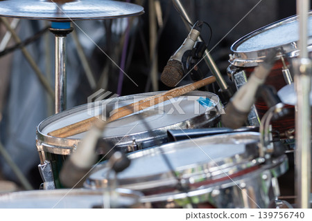 Closeup of drum set microphone drumsticks highlighting live music performance recording stage equipment Closeup of drum set microphone drumsticks highlighting live music performance recording stage equipment 139756740