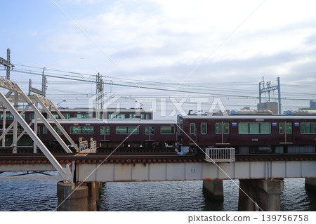 阪急列車駛過新淀川大橋,橋上排列著一排排鐵軌。 阪急列車駛過新淀川大橋,橋上排列著一排排鐵軌。 139756758