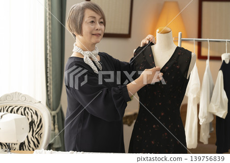 資深女設計師在她們的工作室裡製作服裝。 資深女設計師在她們的工作室裡製作服裝。 139756839