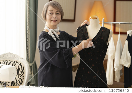 資深女設計師在她們的工作室裡製作服裝。 資深女設計師在她們的工作室裡製作服裝。 139756840