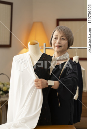 Senior female designers create clothes in their atelier. Senior female designers create clothes in their atelier. 139756903