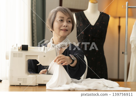 資深女設計師在她們的工作室裡製作服裝。 139756911