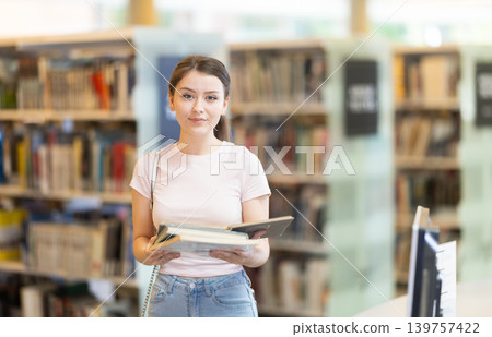 Student with books standing in the library Student with books standing in the library 139757422