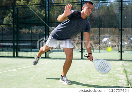 Paddle tennis player preparing to perform left-handed forehand on outdoor court Paddle tennis player preparing to perform left-handed forehand on outdoor court 139757464
