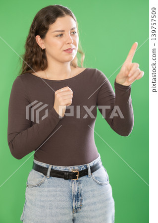 Young woman moves her finger across virtual screen Young woman moves her finger across virtual screen 139757509