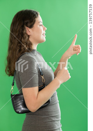 Young woman moves her finger across virtual screen 139757539