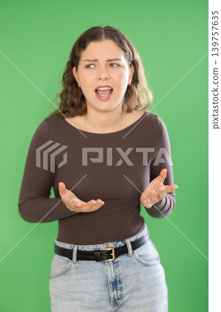 Outraged European young woman is yelling at someone Outraged European young woman is yelling at someone 139757635