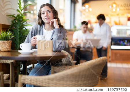 Young woman drinking coffee in cafe Young woman drinking coffee in cafe 139757790