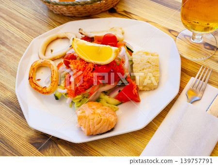 Seafood salad with grilled squid, salmon and vegetables Seafood salad with grilled squid, salmon and vegetables 139757791
