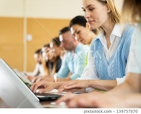 Group of students attentively listening to lecture in university classroom Group of students attentively listening to lecture in university classroom 139757870