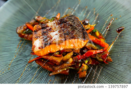 Appetizing roasted salmon steak with vegetable stew Appetizing roasted salmon steak with vegetable stew 139757897