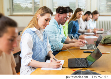 Woman university student sitting at table and handwriting 139757916