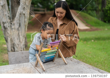 preschool child girl learning and playing colorful wooden abacus with mother preschool child girl learning and playing colorful wooden abacus with mother 139758197