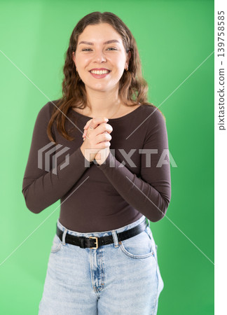 Young woman happy and smiling in front of green screen 139758585