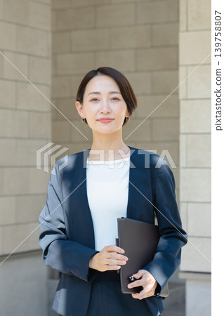 拿著文件的微笑的女商人 拿著文件的微笑的女商人 139758807