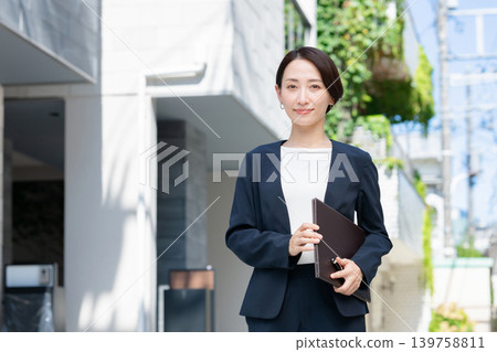 Smiling business woman holding a file Smiling business woman holding a file 139758811