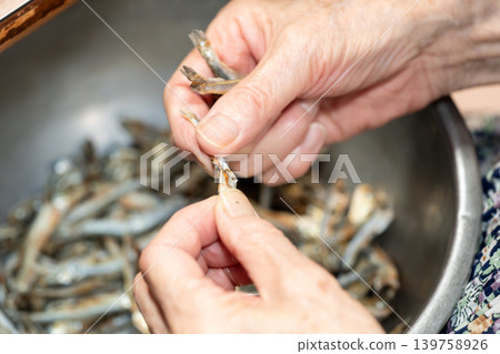 老婦人去掉乾沙丁魚的頭 老婦人去掉乾沙丁魚的頭 139758926