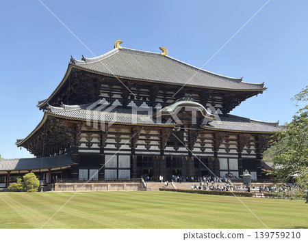 The majestic sight of the Great Buddha Hall of Todai-ji Temple, a World Heritage Site, against a blue sky. The majestic sight of the Great Buddha Hall of Todai-ji Temple, a World Heritage Site, against a blue sky. 139759210