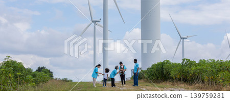 Family with daughter walking on field on wind farm. Family with daughter walking on field on wind farm. 139759281