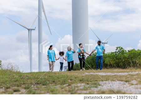 Family with daughter walking on field on wind farm. Family with daughter walking on field on wind farm. 139759282