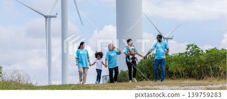 Family with daughter walking on field on wind farm. Family with daughter walking on field on wind farm. 139759283