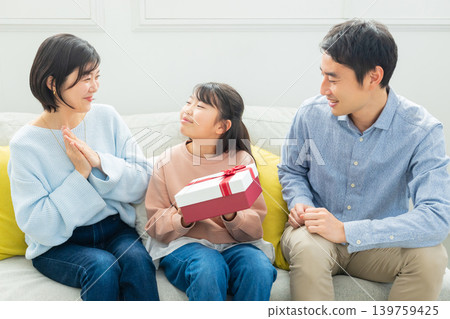 A family exchanging presents in the living room A family exchanging presents in the living room 139759425