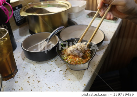 Chopsticks Dipping Dumpling in Spicy Sauce Chopsticks Dipping Dumpling in Spicy Sauce 139759489