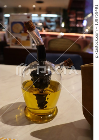 Glass Oil Dispenser with Golden Liquid on Marble Wall Glass Oil Dispenser with Golden Liquid on Marble Wall 139759491