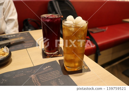 Two Drinks on Restaurant Table with Red Booths Two Drinks on Restaurant Table with Red Booths 139759521