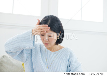 A woman suffering from a headache 139759706