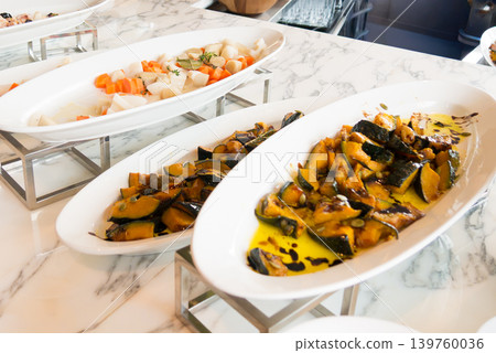 A platter of warm vegetables from a luxury buffet: Grilled pumpkin and colorful vegetables lined up on a marble counter. 139760036