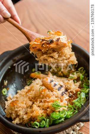 The scene of scooping up salmon and salmon roe rice cooked in an earthenware pot with a wooden spoon. The scene of scooping up salmon and salmon roe rice cooked in an earthenware pot with a wooden spoon. 139760178