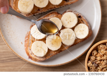 Cranberry sourdough bread with peanut butter, banana slices, granola and honey Cranberry sourdough bread with peanut butter, banana slices, granola and honey 139760430