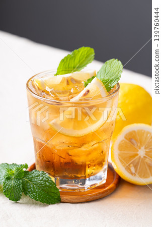 Refreshing iced lemon tea in a glass with sliced lemon and mint leaves Refreshing iced lemon tea in a glass with sliced lemon and mint leaves 139760444