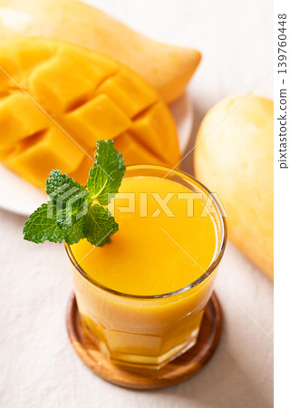 Fresh mango smoothie in a glass with ripe mango slices 139760448