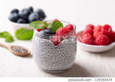 Chia pudding topped with fresh raspberries and blueberries in a glass, Healthy eating Chia pudding topped with fresh raspberries and blueberries in a glass, Healthy eating 139760474