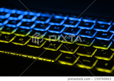 Beautiful colorful modern keyboard with blue and yellow backlight. Backlight of the keyboard in colors of Ukrainian flag Beautiful colorful modern keyboard with blue and yellow backlight. Backlight of the keyboard in colors of Ukrainian flag 139760663