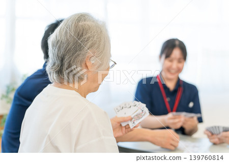 集體住宅或養老院裡的老人和一位女性護理人員打牌 集體住宅或養老院裡的老人和一位女性護理人員打牌 139760814