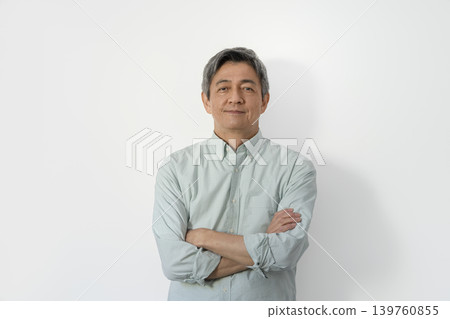 一位六十多歲的男子雙手交叉抱在胸前，面帶微笑，直視鏡頭。 139760855
