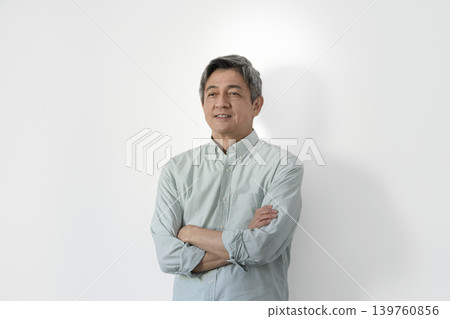 一位六十多歲的男子雙手交叉抱在胸前。 一位六十多歲的男子雙手交叉抱在胸前。 139760856
